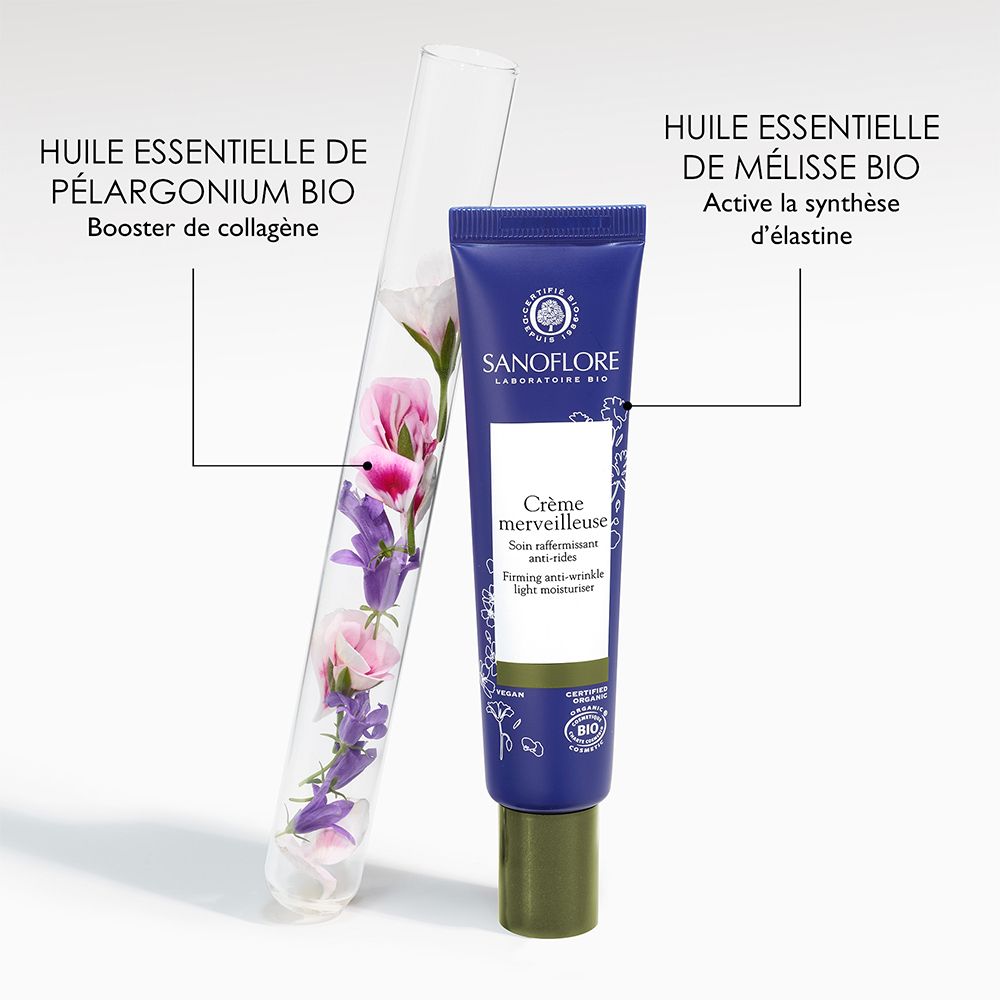 Reageerbuis met bloemen naast tube. Sanoflore Crème merveilleuse. Bevat essentiële olie van Pelargonium en Citroenmelisse.