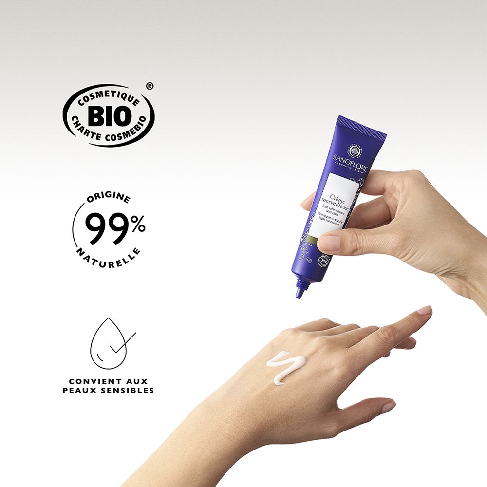 Hand met crème. Sanoflore Crème merveilleuse. 99% natuurlijk. Geschikt voor de gevoelige huid. Bio-certificering.