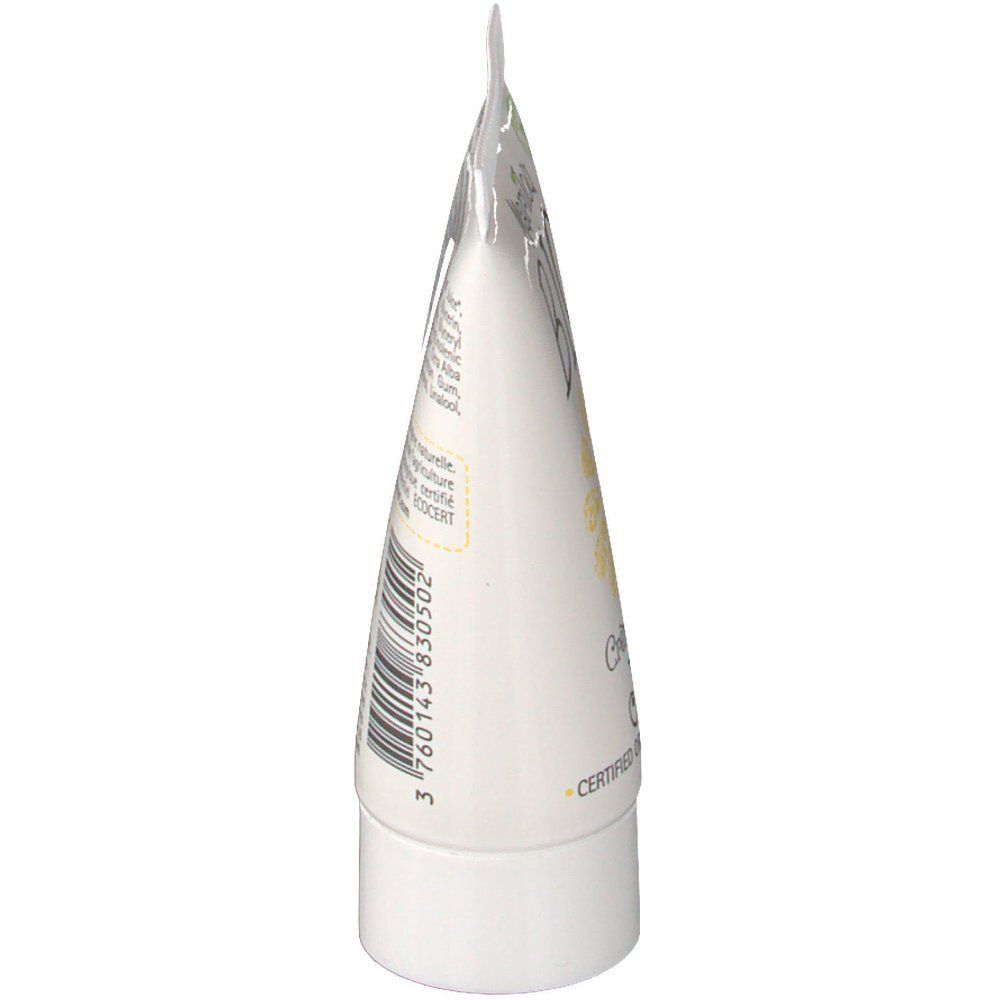 Vue latérale d'un tube blanc. Informations et texte imprimés visibles. La tête du tube est pliée.