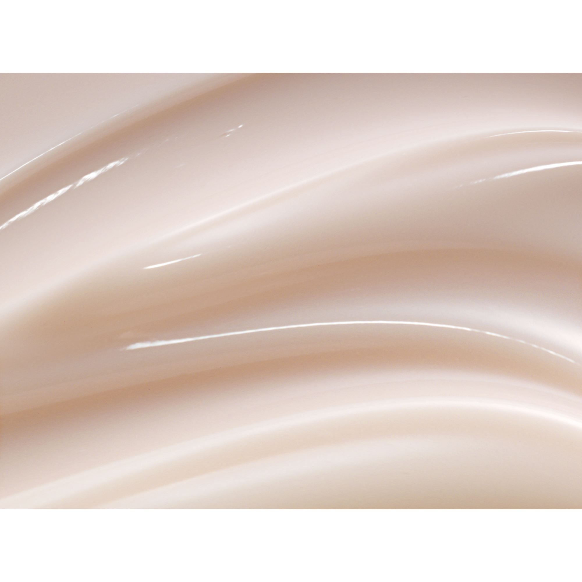 Close-up van een crèmekleurige, glanzende crème. Golfachtige textuur.