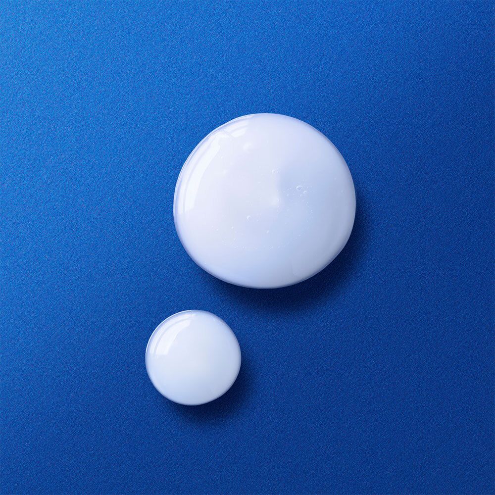 Twee witte, ronde druppels op blauwe achtergrond. De bovenste druppel is groter.
