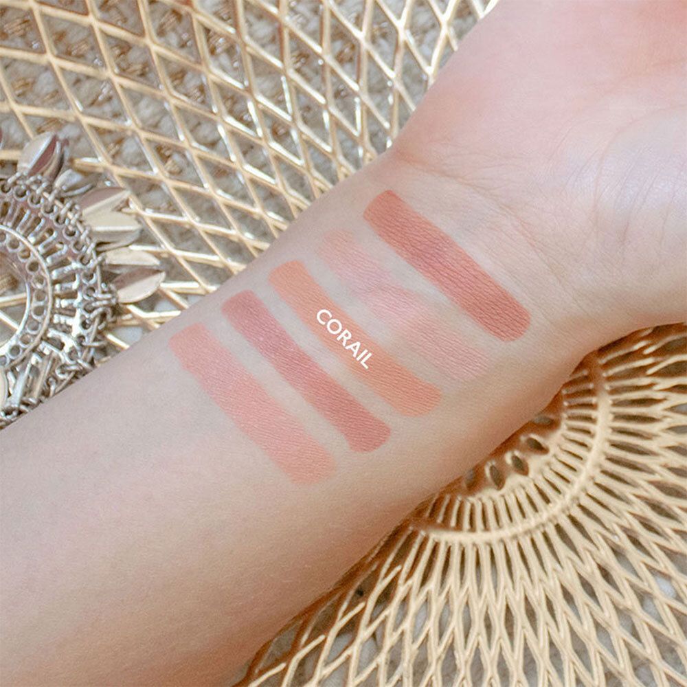 Hand met blush swatches. Koraalkleur. Tekst 'CORAIL' zichtbaar.