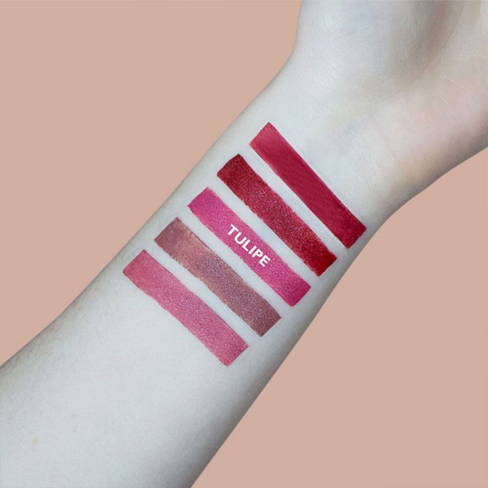 Arm met lipstick-swatches in verschillende roodtinten. Opschrift: TULIPE.