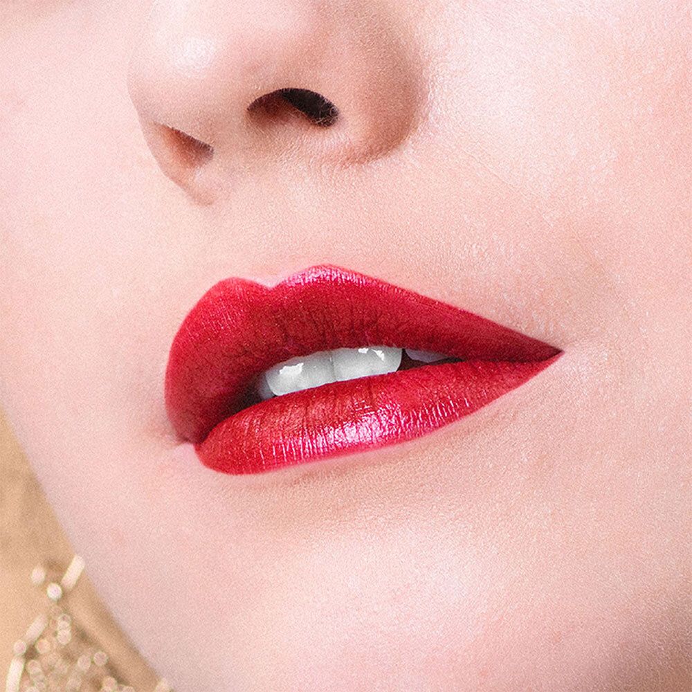 Gros plan sur des lèvres avec du rouge à lèvres rouge. Dents visibles.