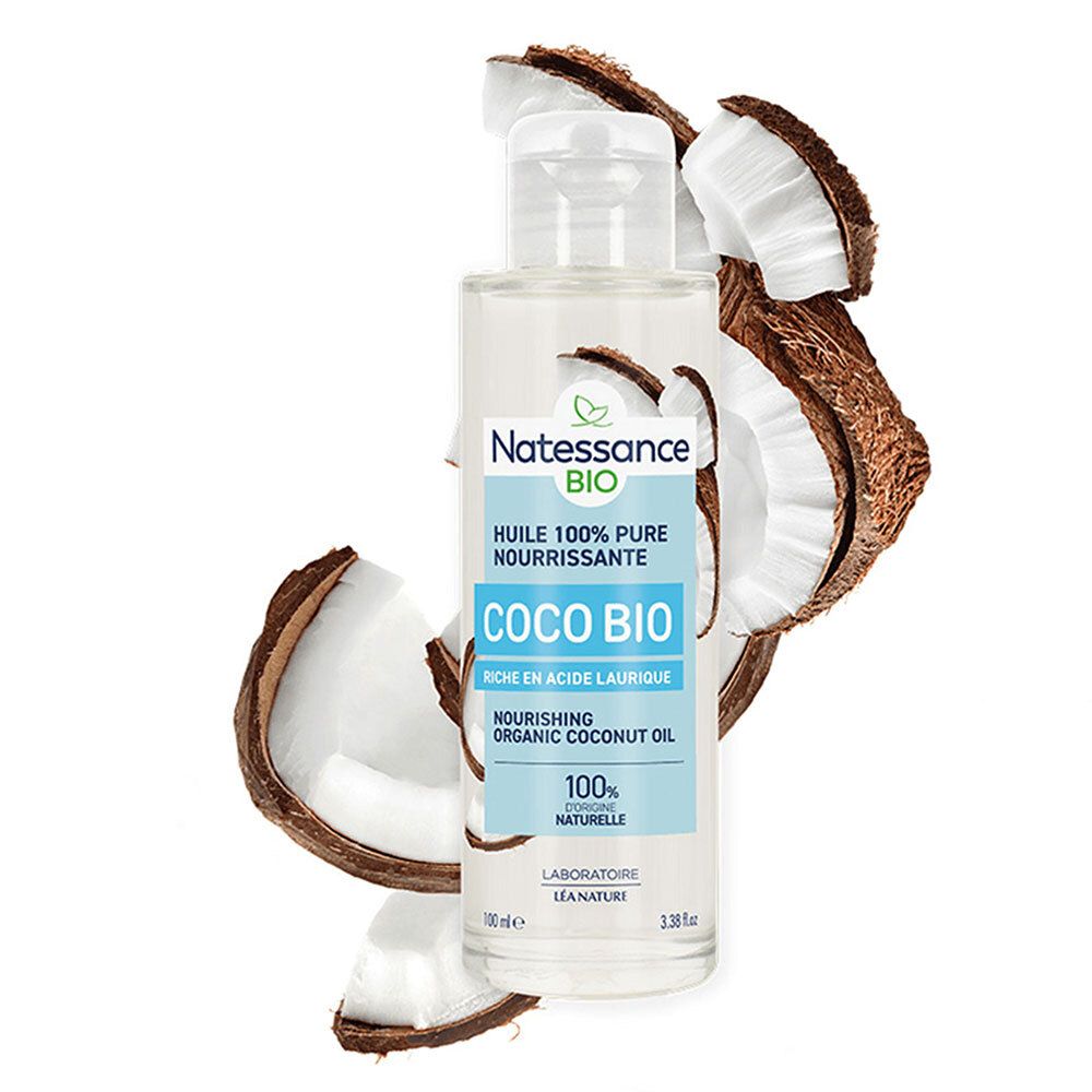 Glazen fles met zilveren dop, omringd door kokosschalen. Etiket met Natessance Coco Bio en tekst.