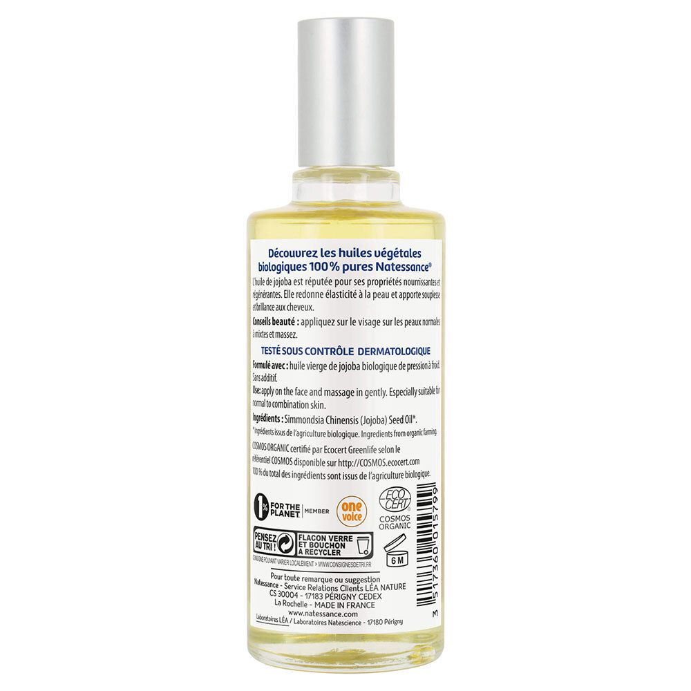 Achterkant van de glazen fles. Tekstinformatie, ingrediënten, certificeringen en logo's. Transparante vloeistof zichtbaar.