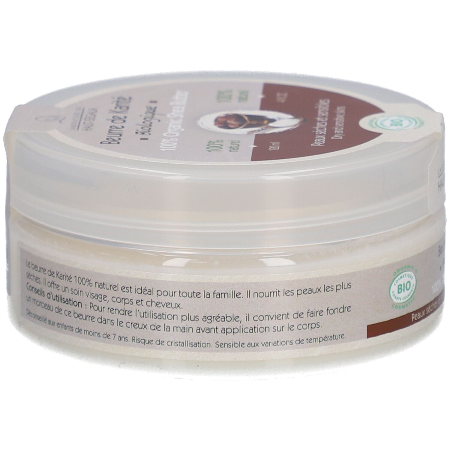 Cilindrische pot met deksel. Opschrift: Beurre de Karité Biologique, 100% Organic Shea Butter. Bio-label. Tekst op achterkant.