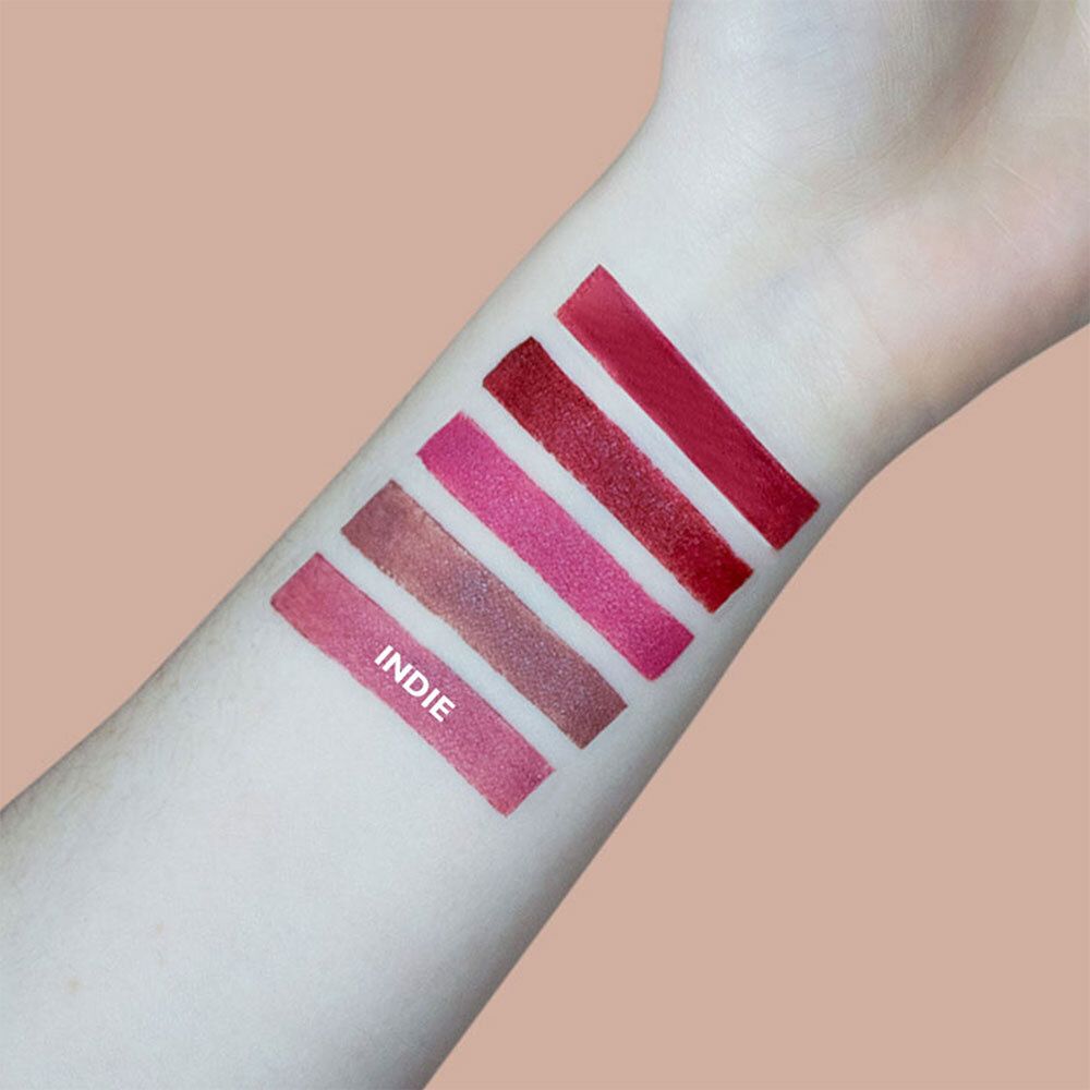 Arm met vijf lipstickkleuren. Tint Indie. Opschrift Indie. Verschillende roze tinten.