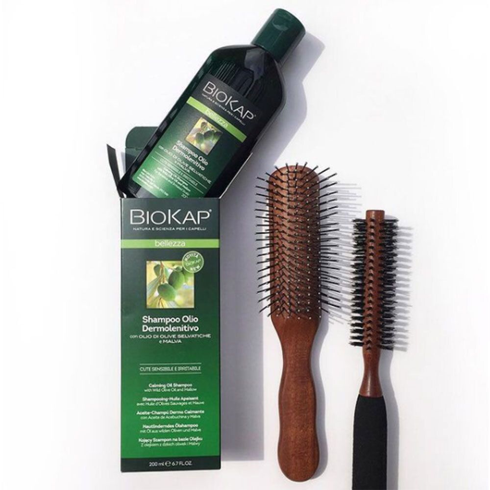 BIOKAP fles en verpakking met twee houten borstels. Productnaam en merk duidelijk zichtbaar.