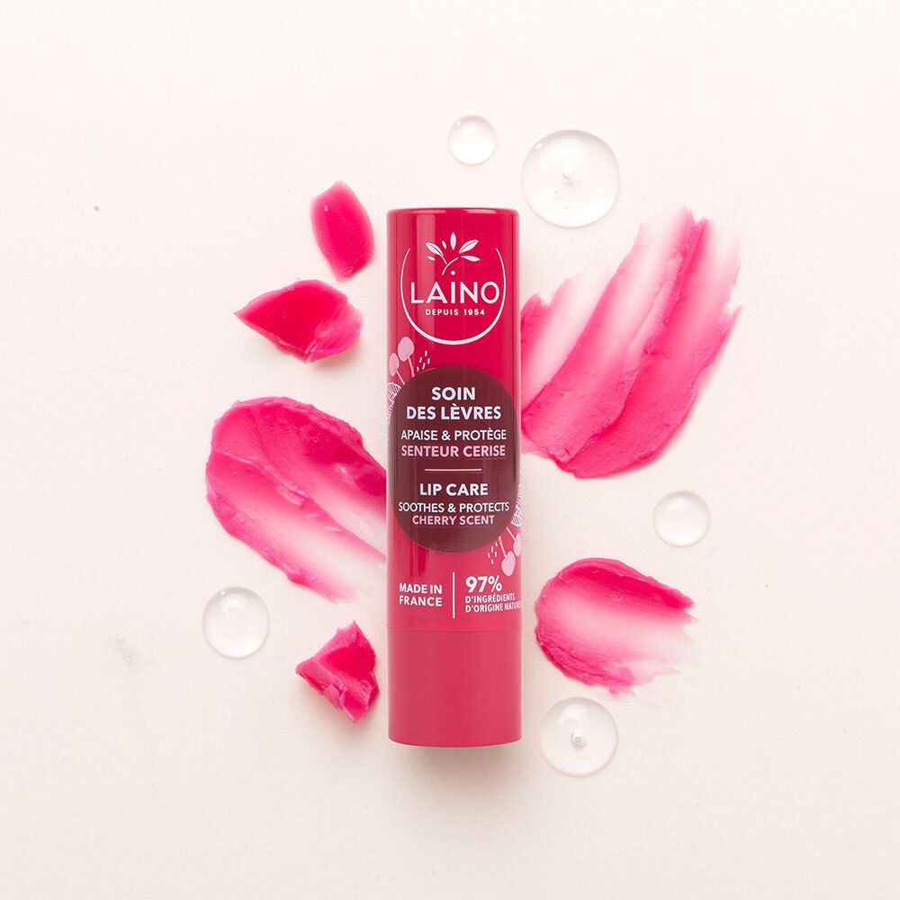 Rode lippenbalsem met roze lippenstiftstreken en waterdruppels op witte achtergrond.