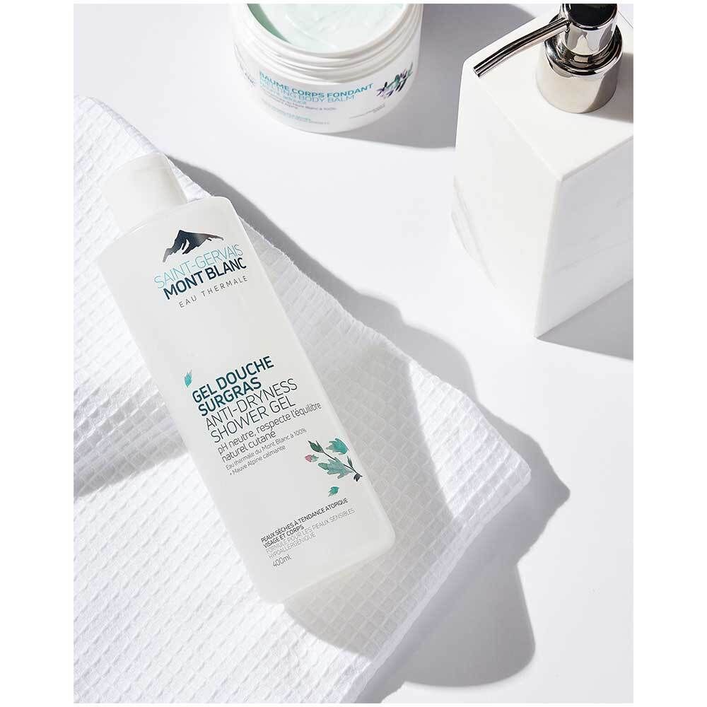 Flacon de gel douche Saint-Gervais MONT BLANC sur une serviette blanche. Pot de crème et distributeur de savon à côté.