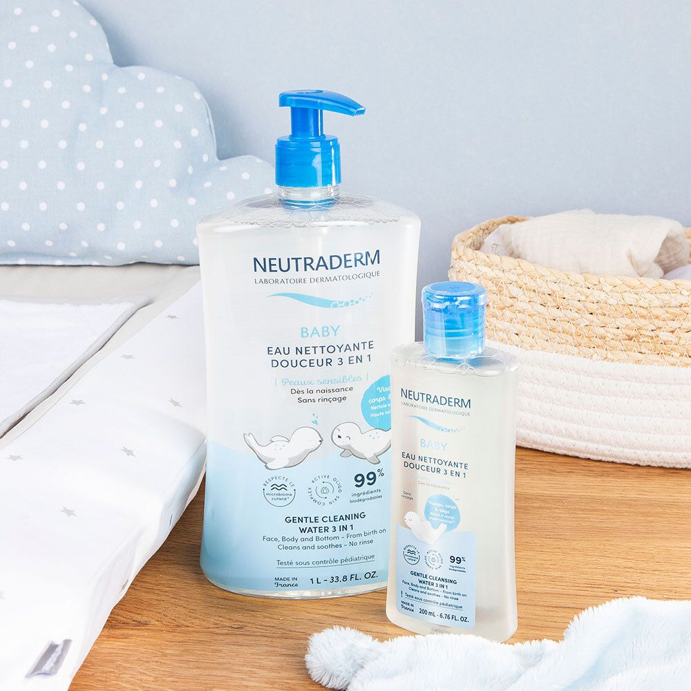 Twee Neutraderm Baby reinigingswaterflessen. Een grote en een kleine. Op een aankleedtafel. Babyaccessoires.