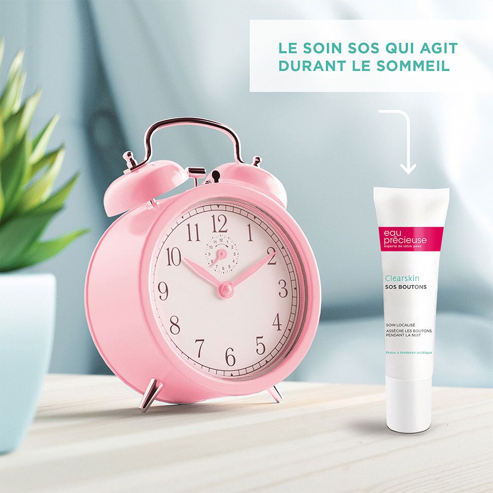 Roze wekker en tube Eau Précieuse Clearskin SOS Boutons. Tekst: Le soin SOS qui agit durant le sommeil.