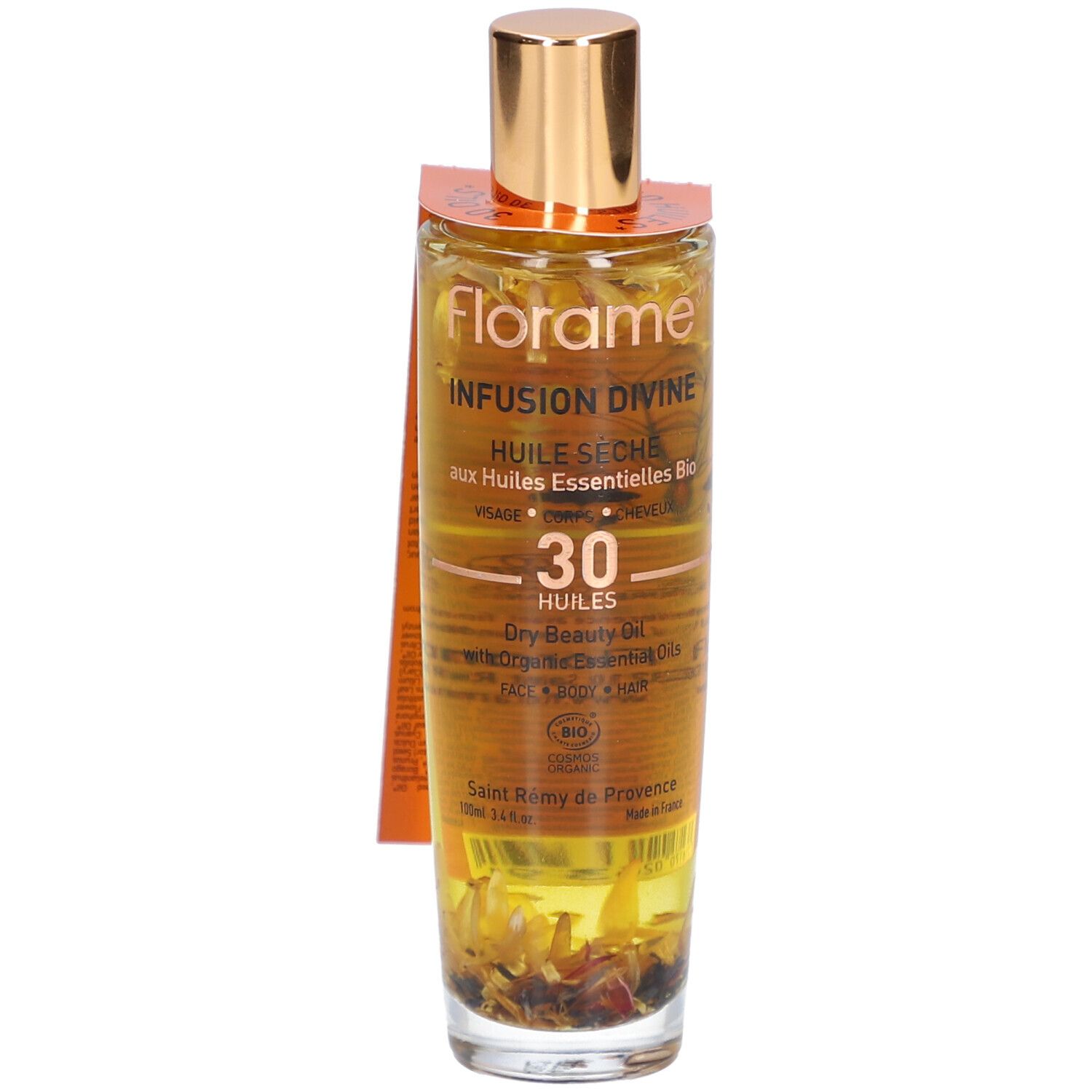 Glazen fles met gouden dop en etiket. Bevat een vloeistof met bloemen. Opschrift: Infusion Divine, Huile Seche.