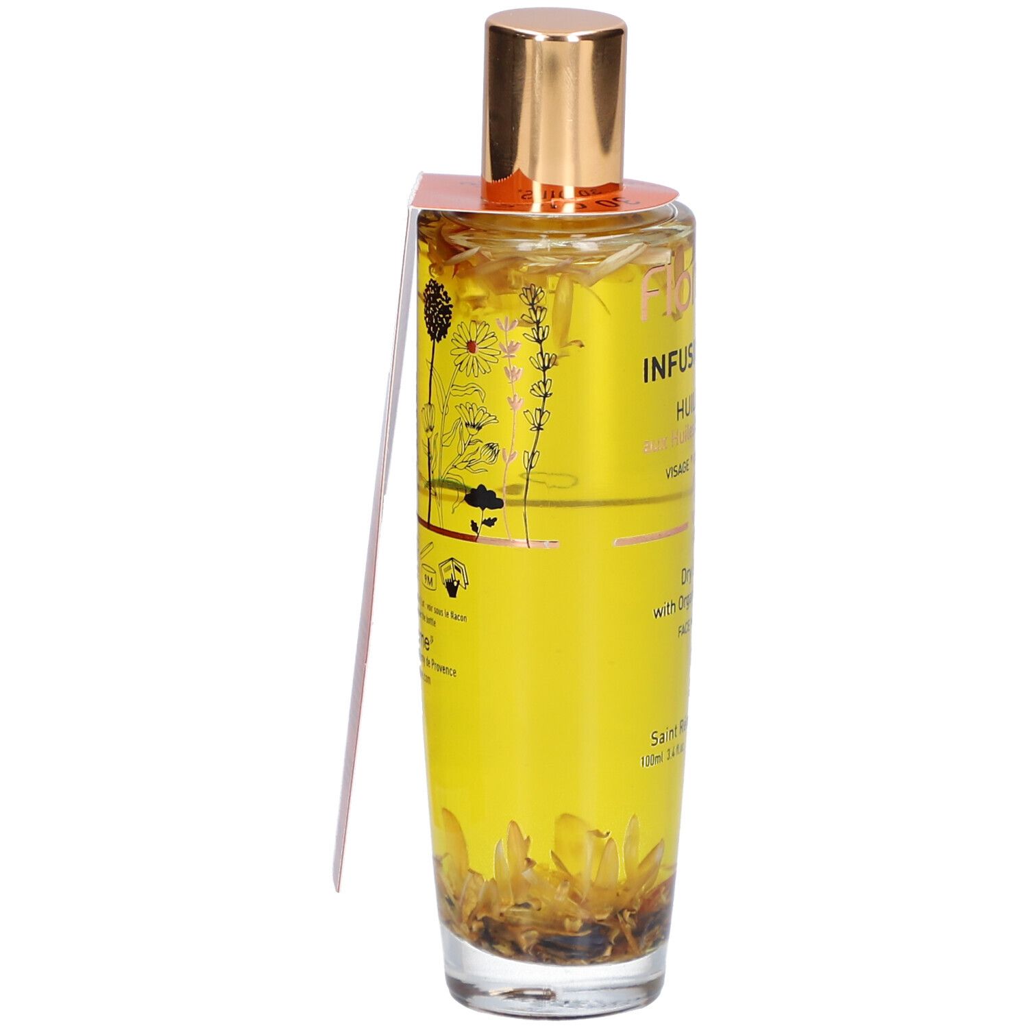 Glazen fles met gouden dop en etiket. Bevat een gele vloeistof met bloemen. Opschrift: Infusion Divine, Huile Seche.
