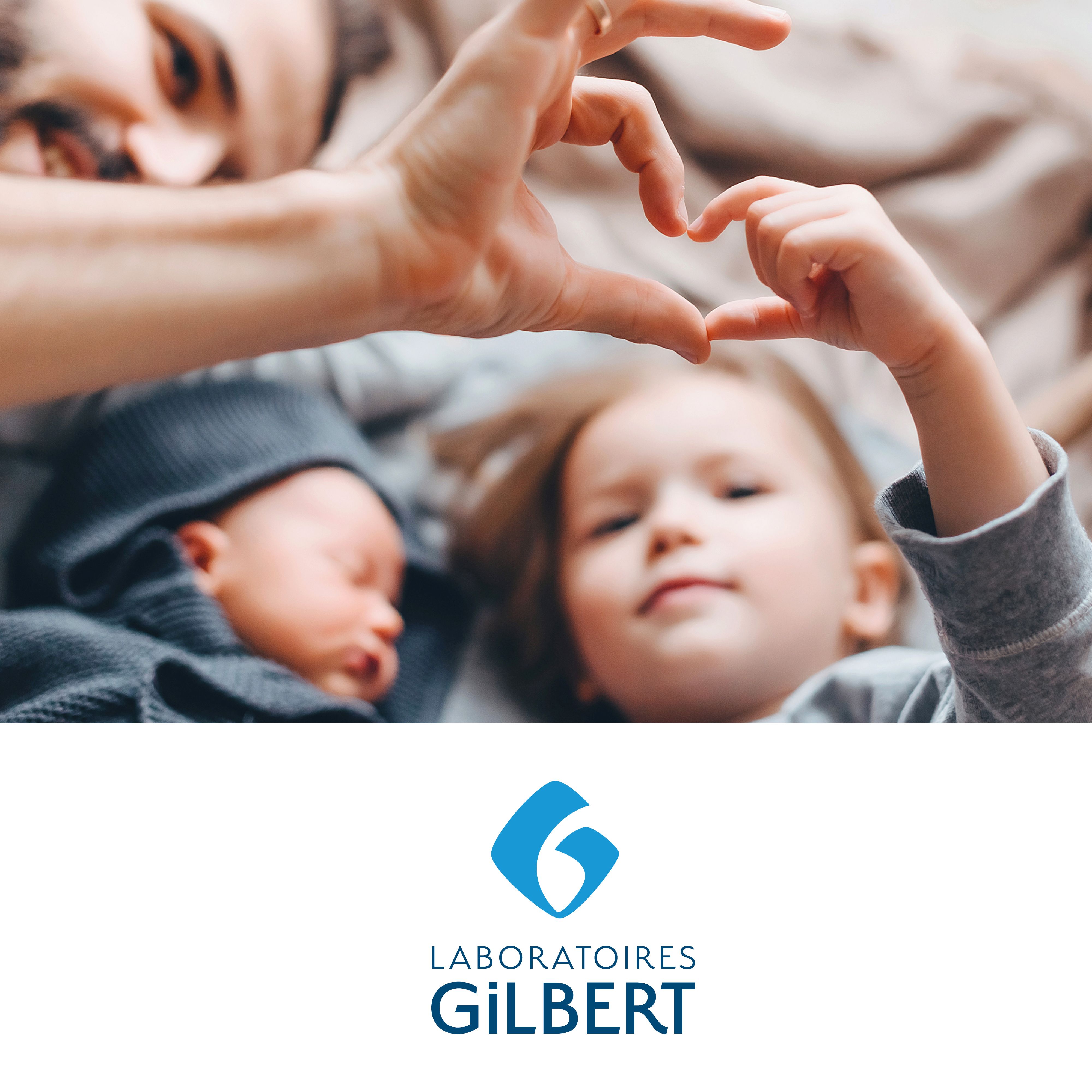 Familie vormt hart met handen. Baby en kind op de achtergrond. Logo Laboratoires Gilbert.