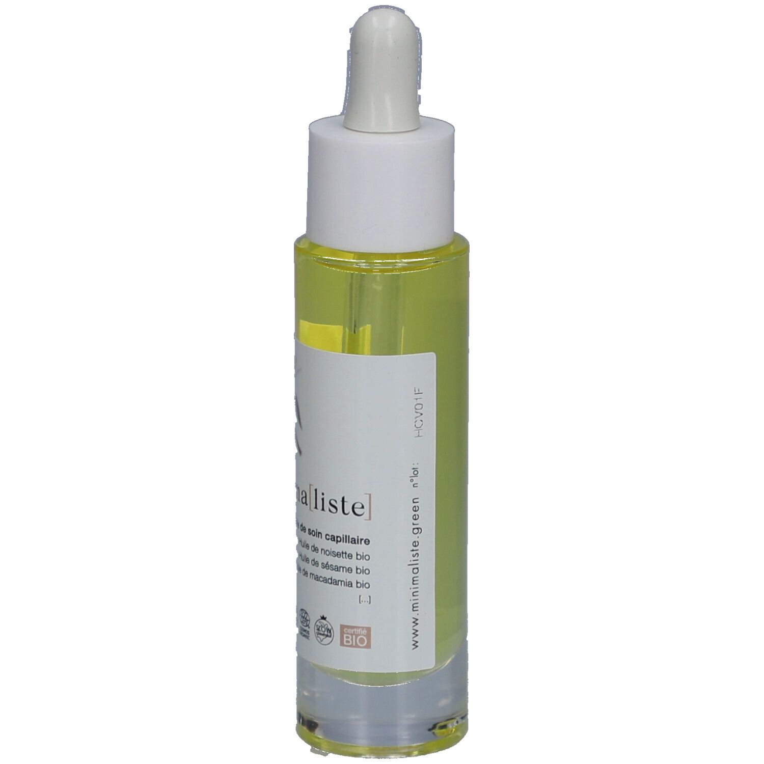 Haarolie fles met pipet. Transparante houder met gele vloeistof. Witte dop. Etiket met productnaam en tekst.