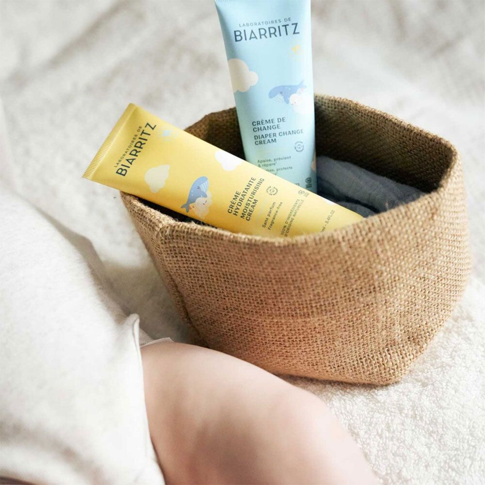 Twee tubes in een mand. Opschrift: Laboratoires de Biarritz, Crème Hydratante, Crème de Change, Diaper Change Cream.