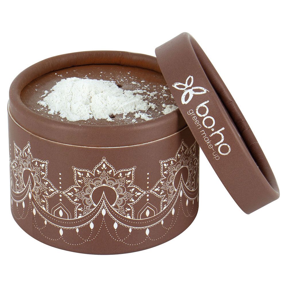 Boîte ronde marron avec poudre libre. Couvercle à côté. Marque : bo-ho green make-up. Motif blanc sur la boîte.