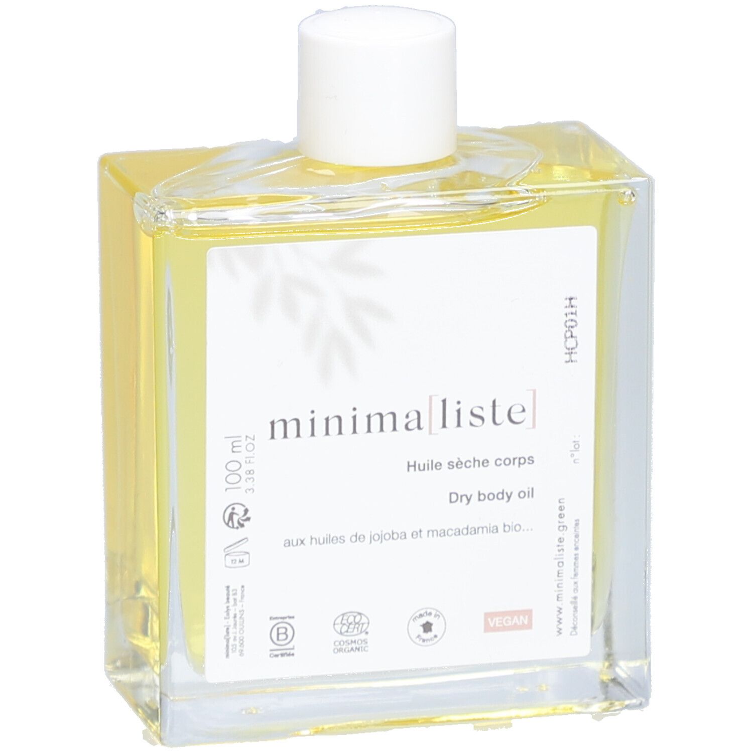 Glazen fles met gele olie en witte dop. Etiket met productnaam en informatie. Close-up.