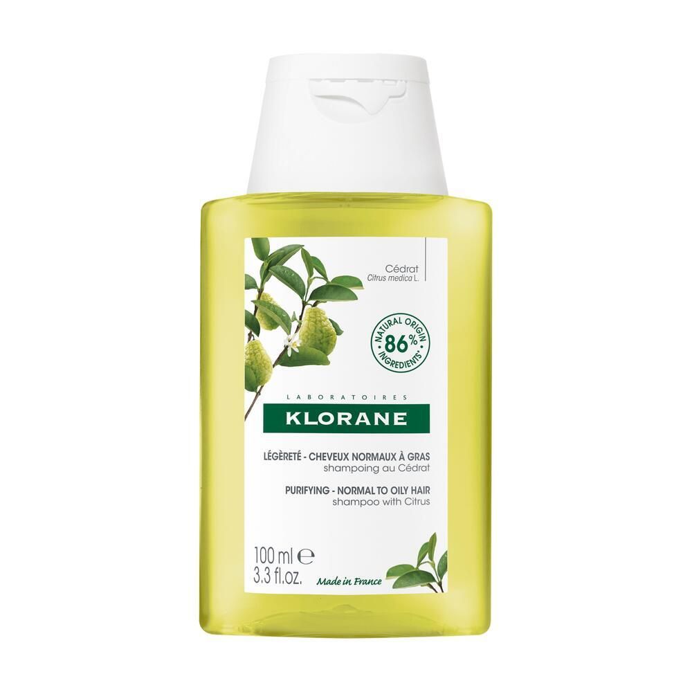 Flacon de KLORANE Shampooing au Cédrat. Liquide jaune, bouchon blanc. Étiquette avec informations produit et illustration de citron.