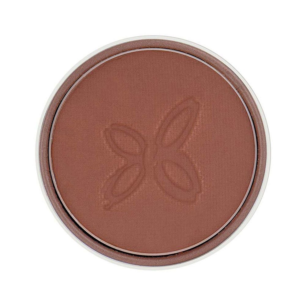 Ronde bruine oogschaduw in een witte houder. Een reliëfpatroon is zichtbaar op het oppervlak.