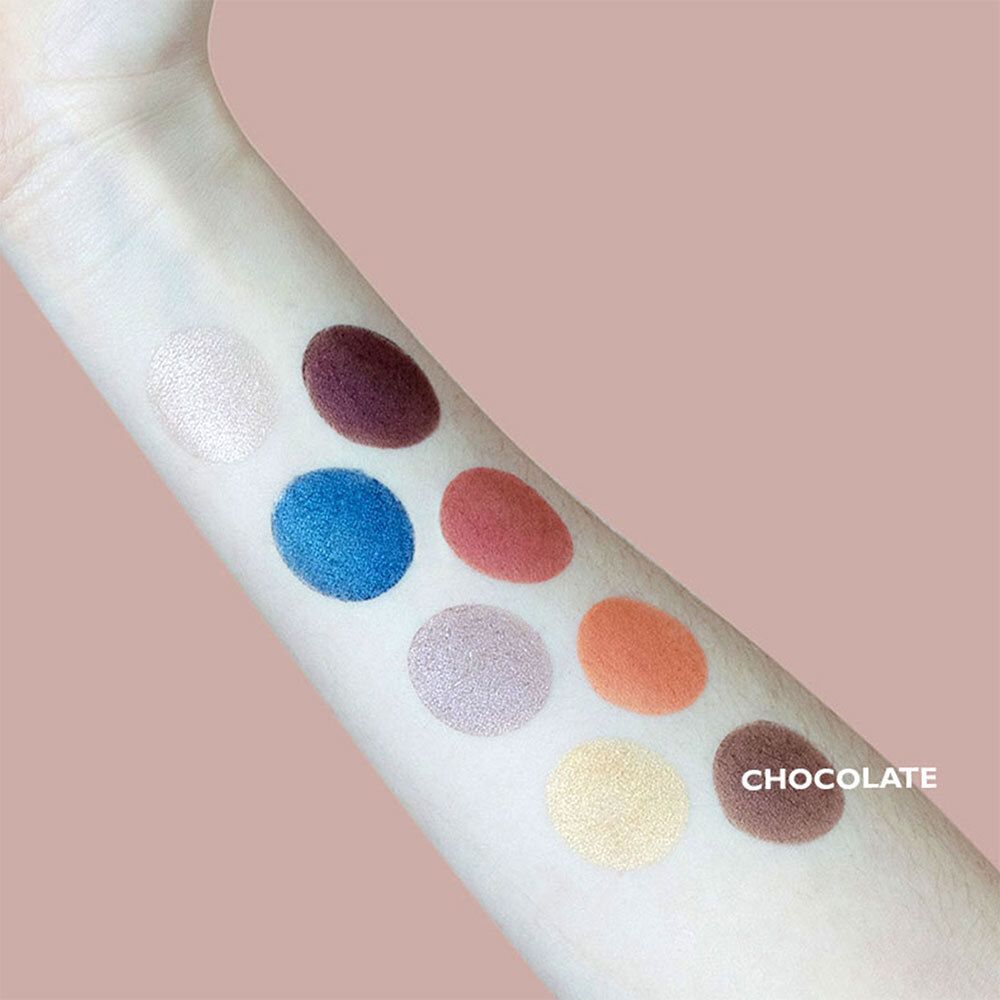 Arm met oogschaduwstalen. Verschillende kleuren, waaronder bruin. Tekst 'CHOCOLATE'.