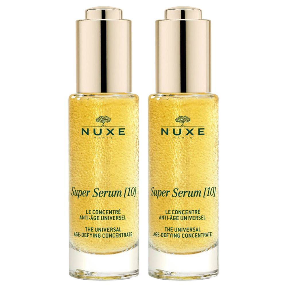 Twee flacons gouden serum. Opschrift: NUXE, Super Serum [10], Le concentré anti-âge universel, The universal age-defying concentrate.