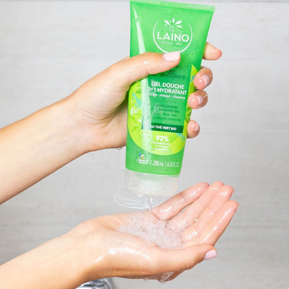Handen houden een groene tube vast en persen het product eruit. Schuim is zichtbaar in de handpalm.