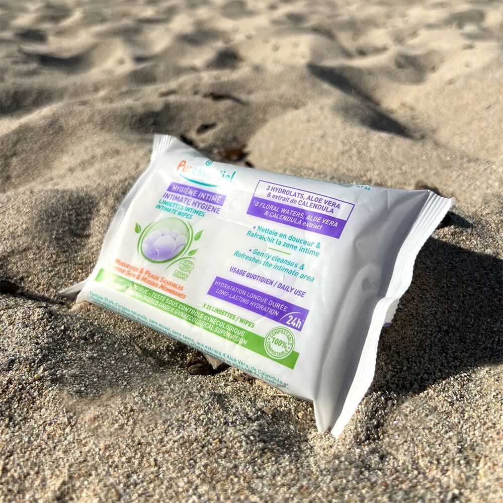 Paquet de lingettes intimes sur le sable. Texte: HYGIÈNE INTIME, 25 lingettes, hydratation 24h. Avec Aloe Vera et extrait de Calendula. Bio.