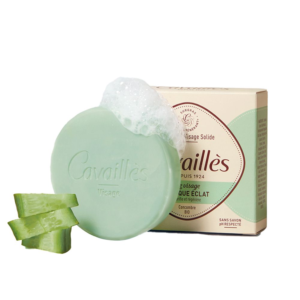 Savon rond vert avec mousse et tranches de concombre. Emballage avec nom et logo du produit.