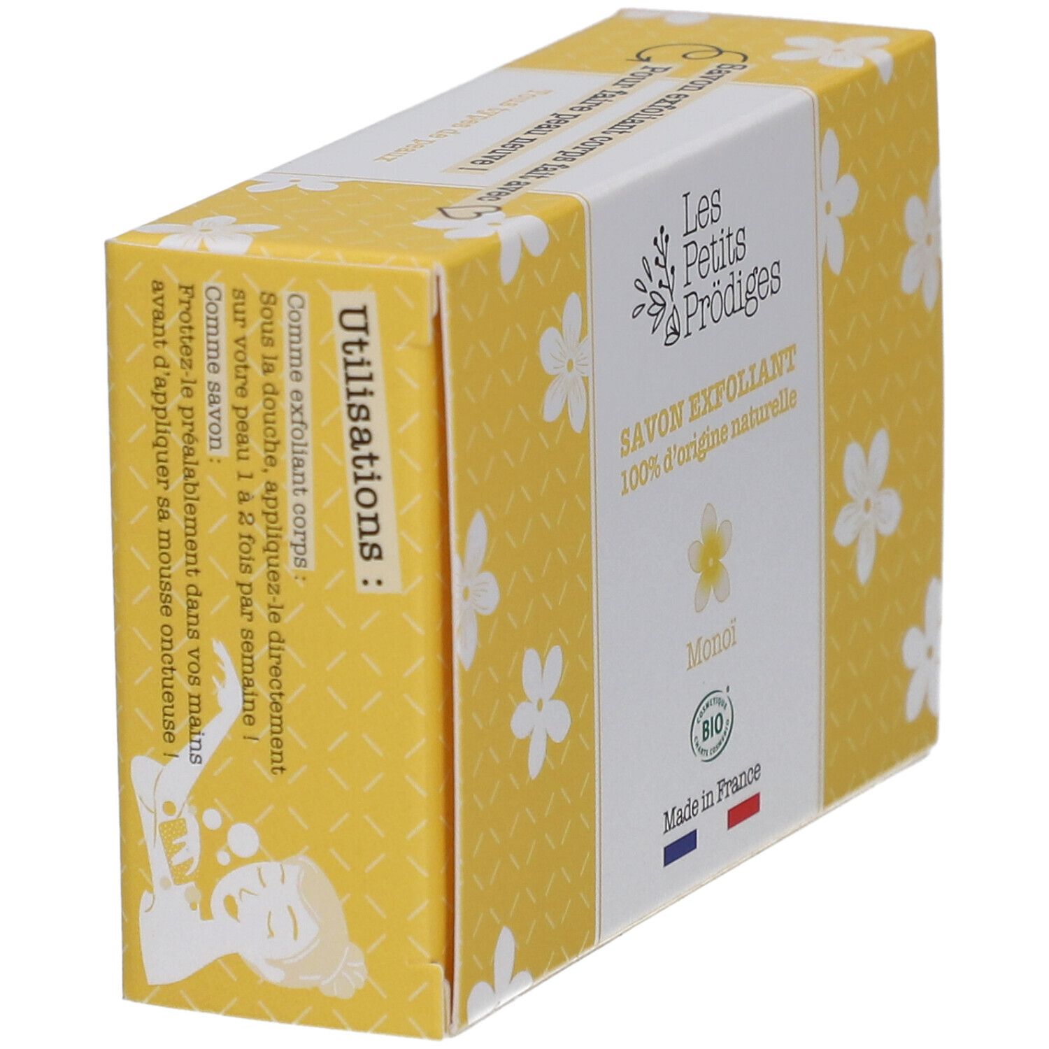 Gele doos met witte bloemmotieven. Opschrift: SAVON EXFOLIANT, 100% d'origine naturelle, Monoi, BIO. Franse vlag. Gebruiksaanwijzing.