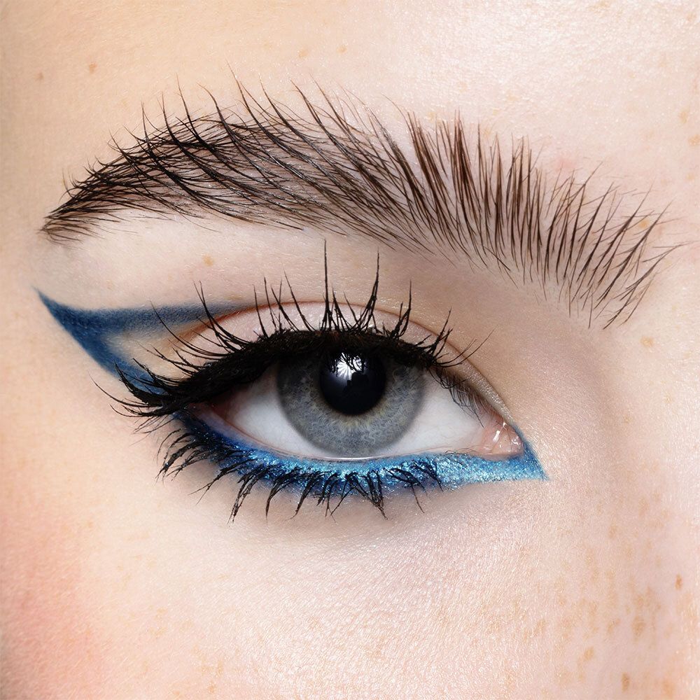 Oog met turquoise eyeliner. Wimpers opgemaakt.