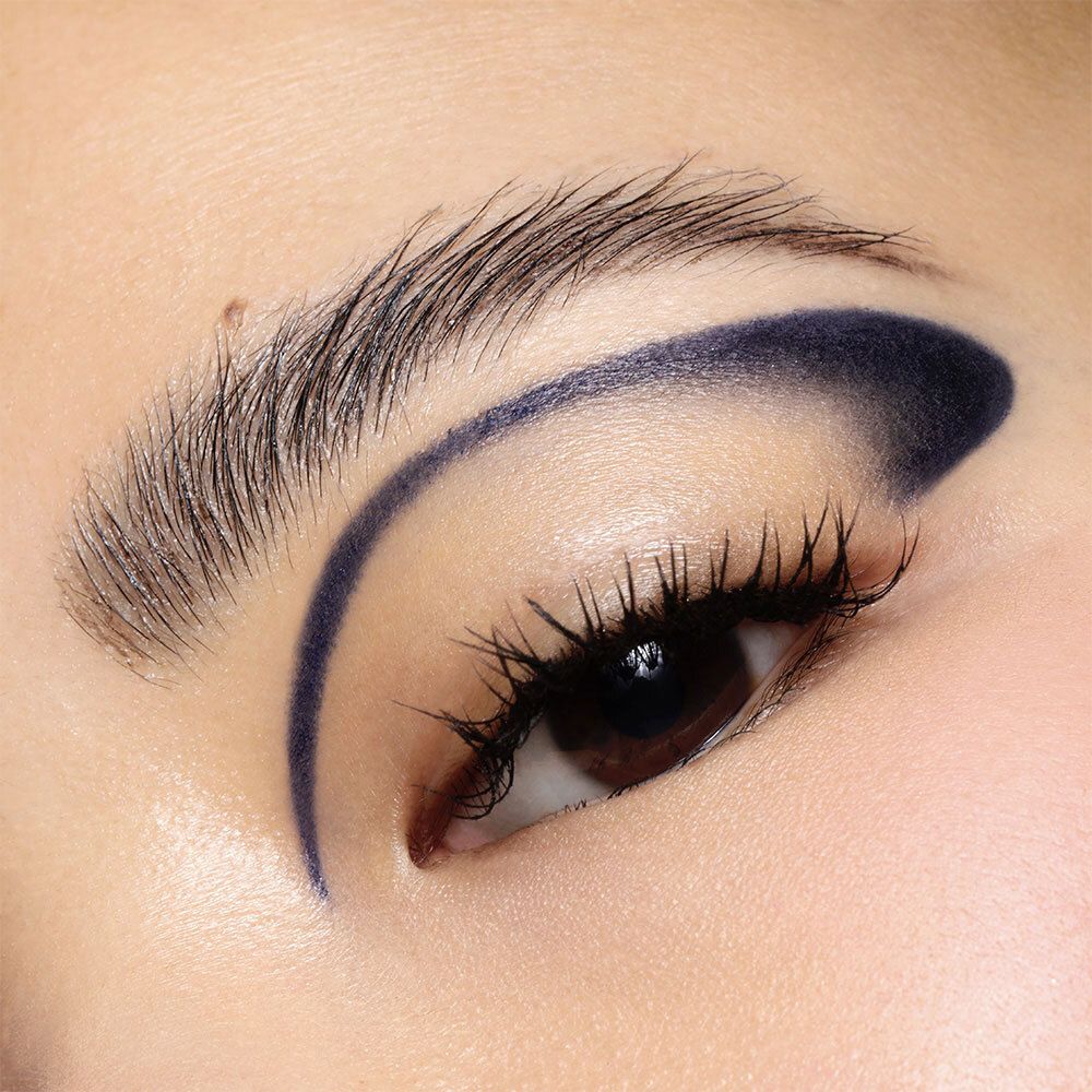 Oeil avec trait d'eye-liner bleu. Sourcil et cils visibles.