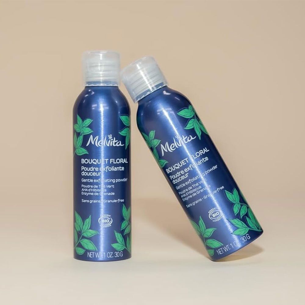 Twee blauwe flessen met witte dop. Opschrift: Melvita, Bouquet Floral, Poudre exfoliante douceur. Bio-certificering.