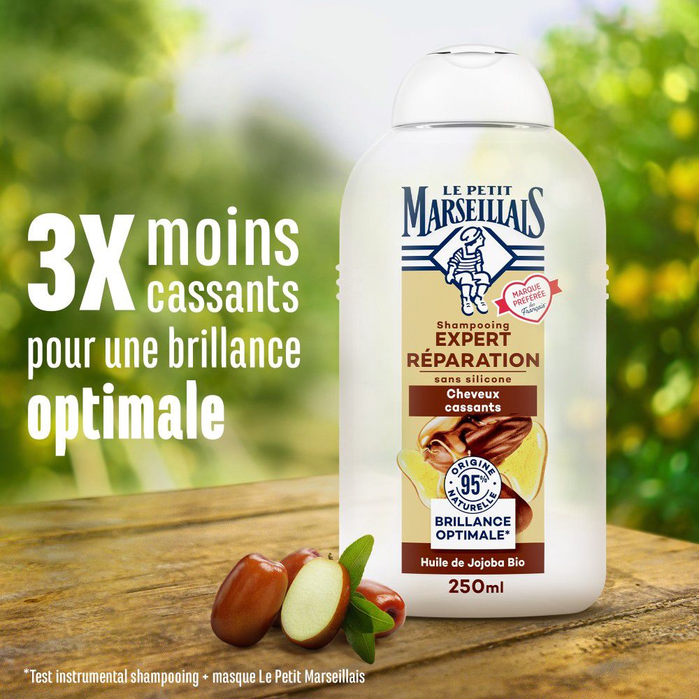Flacon de shampooing et fruits sur bois. Texte: 3x moins de cassures, pour une brillance optimale. Le Petit Marseillais.