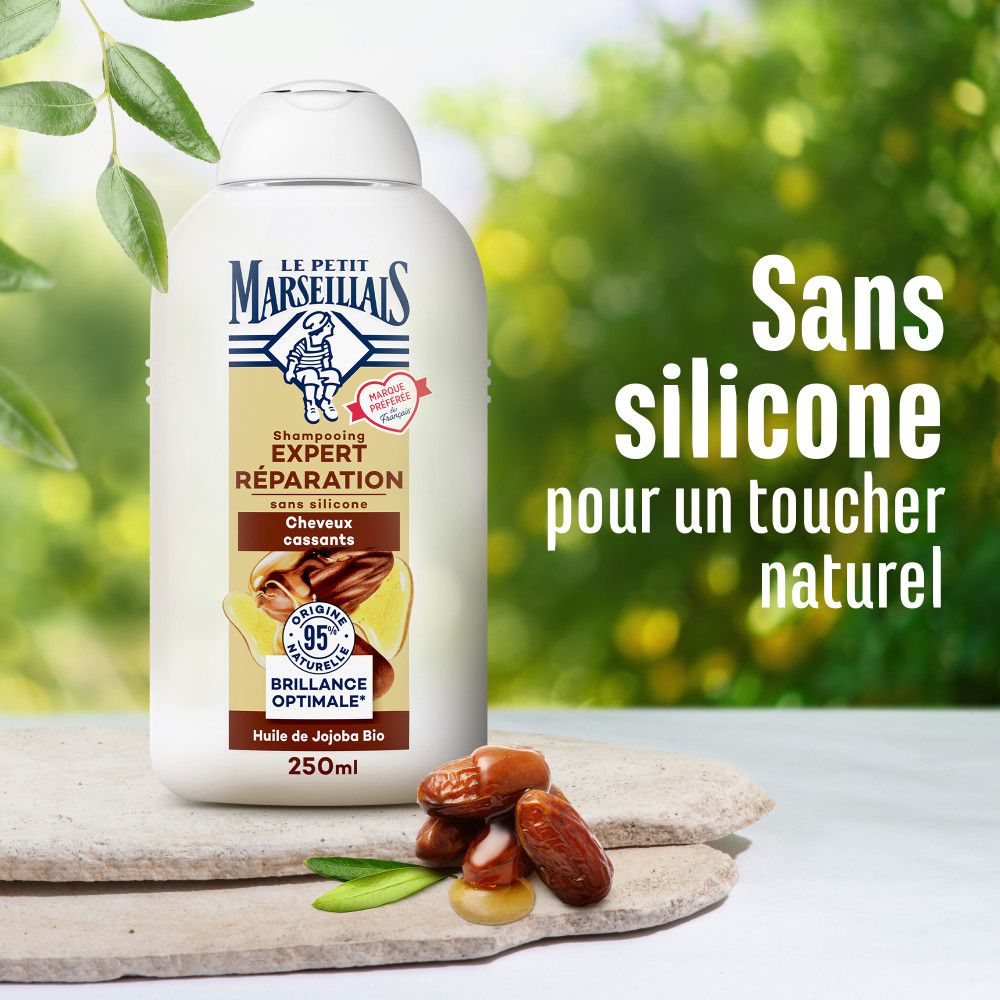 Flacon de shampooing et fruits sur bois. Texte: Sans silicone, pour un toucher naturel. Le Petit Marseillais.