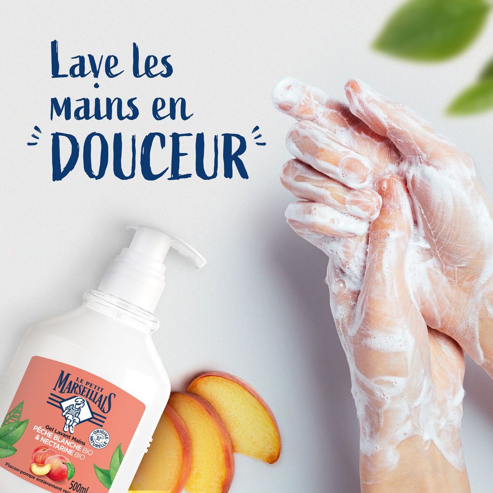 Mains lavées avec du savon liquide moussant d'un flacon pompe blanc.