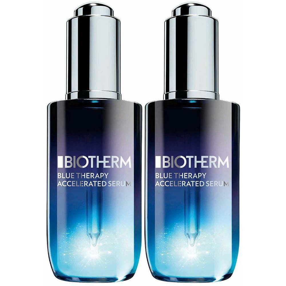 Deux flacons de sérum Biotherm Blue Therapy Accelerated. Flacons en verre bleu avec bouchons argentés et pipettes. Noms de produits et logos visibles.