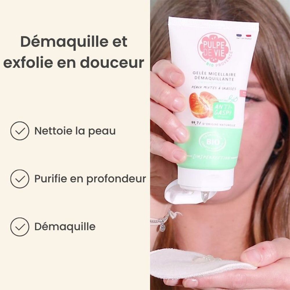 Une personne tient un tube de Gel Micellaire Démaquillante. Sur le tube: PULPE DE VIE, certification BIO, orange.