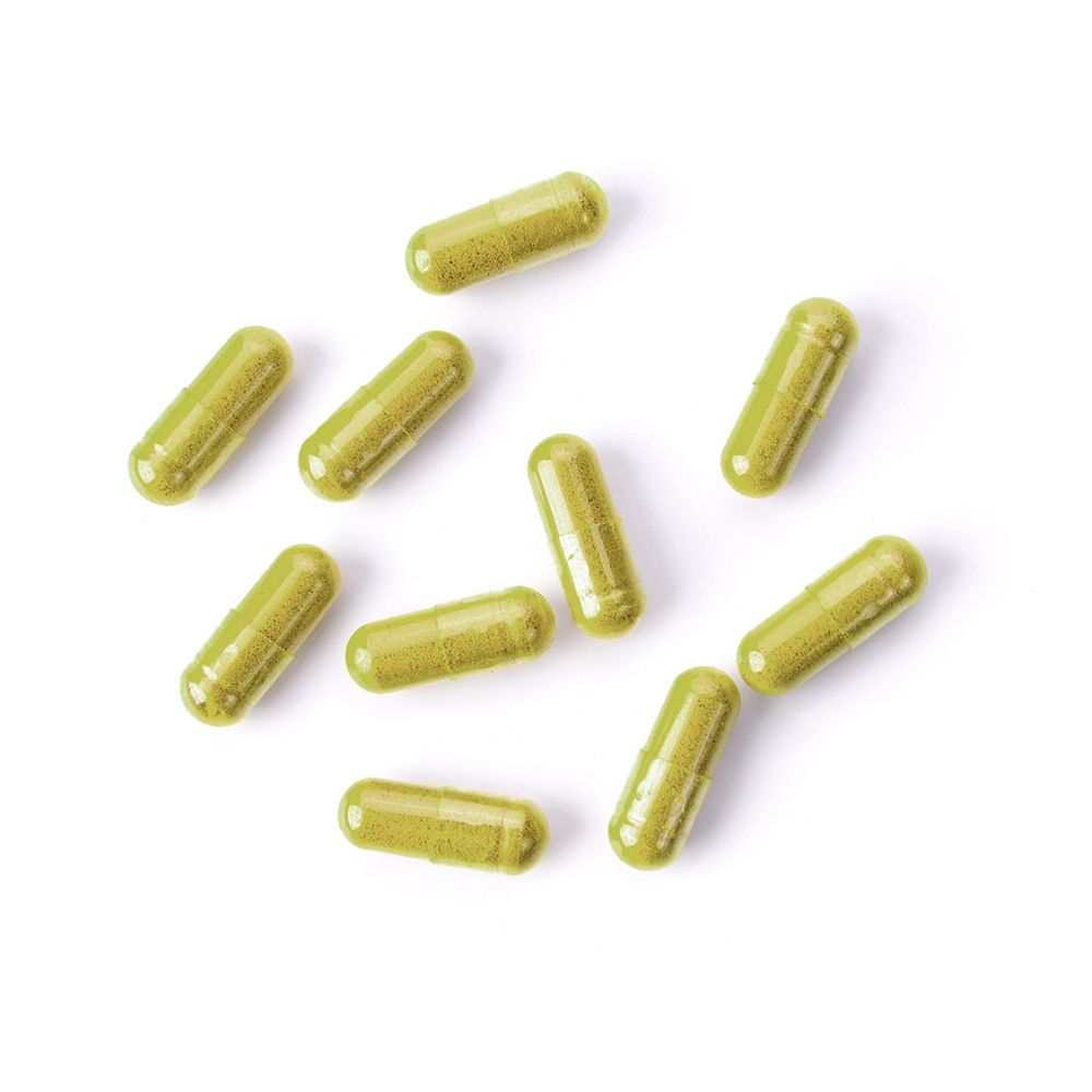 Tien groene capsules op witte achtergrond. Capsulevorm.