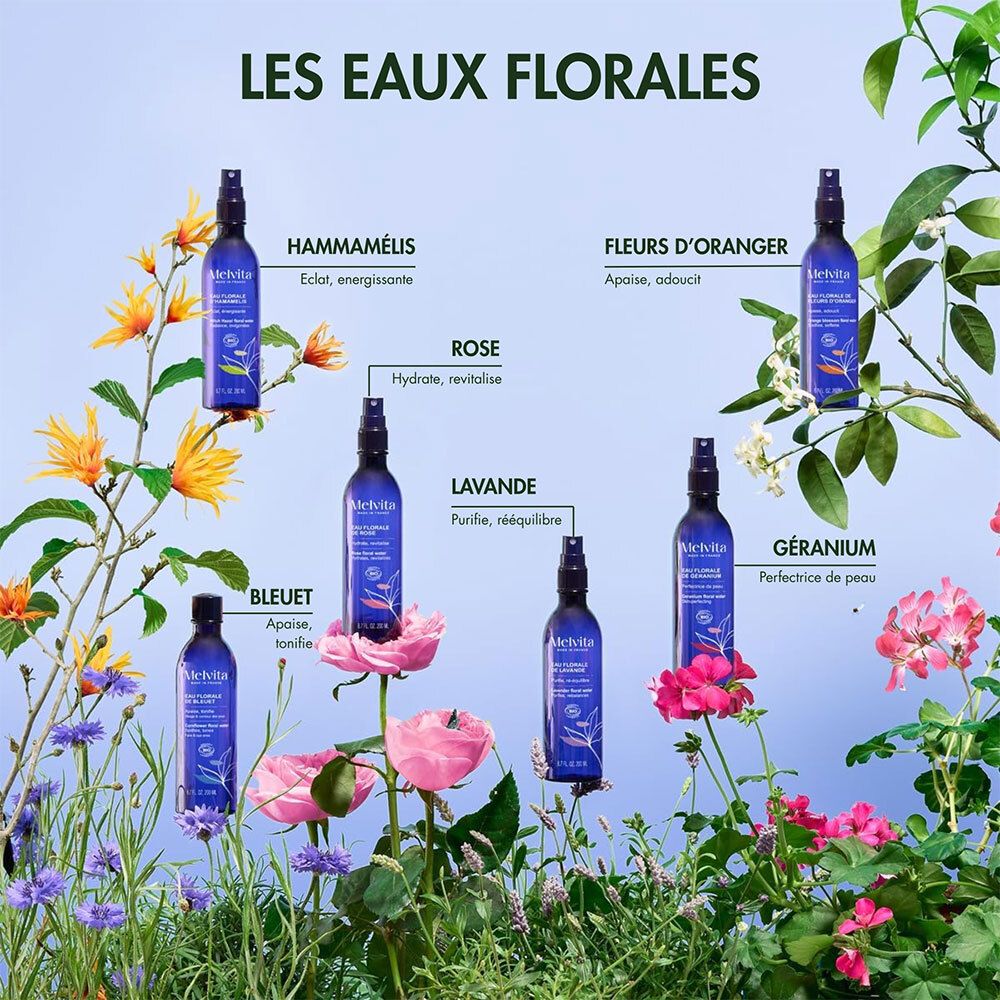 Divers flacons pulvérisateurs bleus avec des fleurs. Texte: Hamamélis, Fleurs d'oranger, Rose, Lavande, Bleuet, Géranium. Melvita.