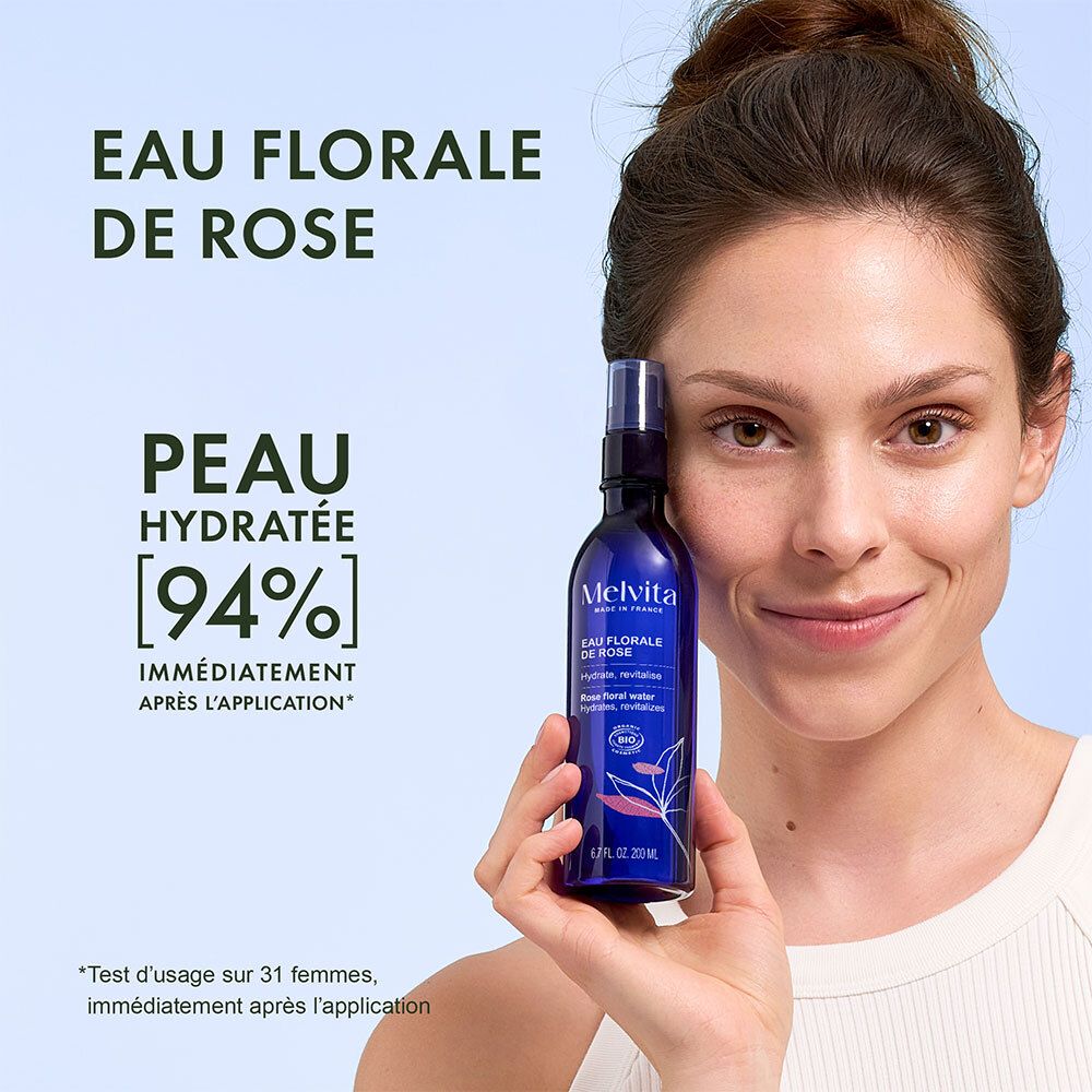 Vrouw houdt Melvita Rozenbloesemwater fles vast, huid 94% gehydrateerd.