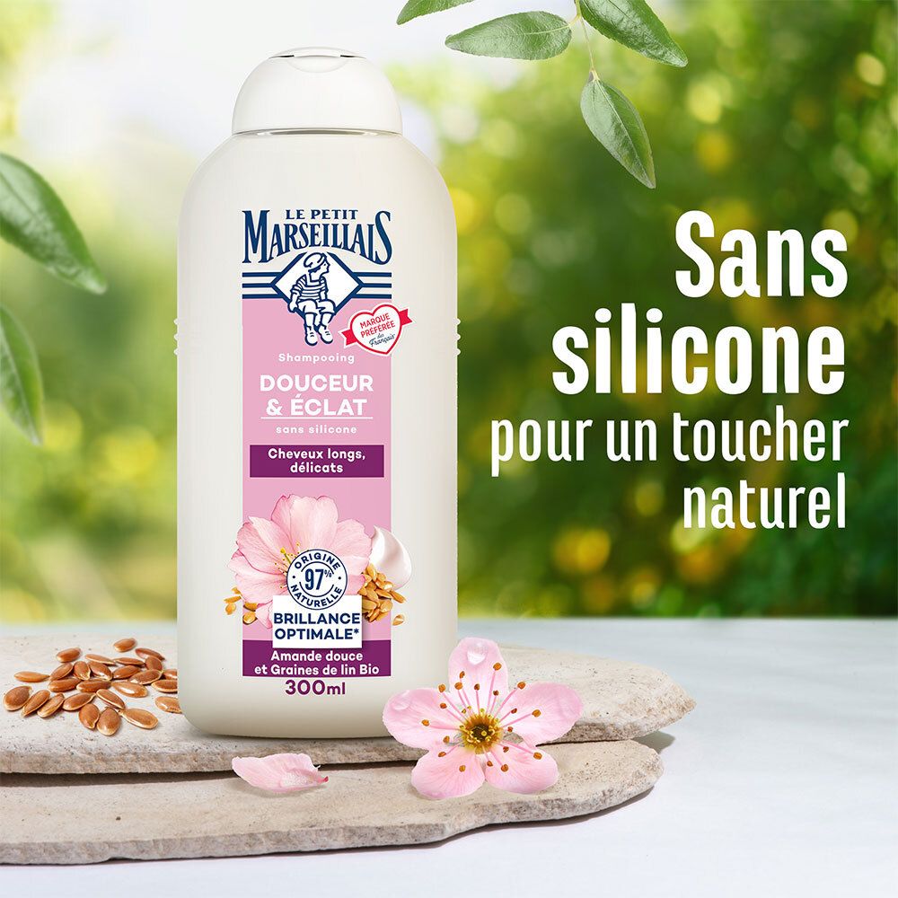 Shampoo fles met tekst. Achtergrond: stenen, bloemen, zaden. Tekst: Sans silicone. Merk: Le Petit Marseillais.