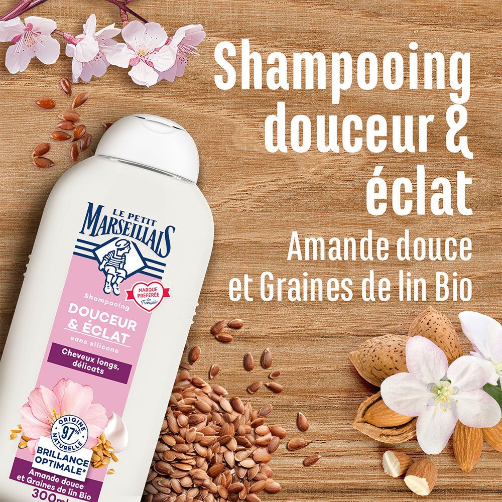Shampoo fles met tekst. Achtergrond: hout, bloemen, zaden. Tekst: Shampooing Douceur & éclat. Merk: Le Petit Marseillais.