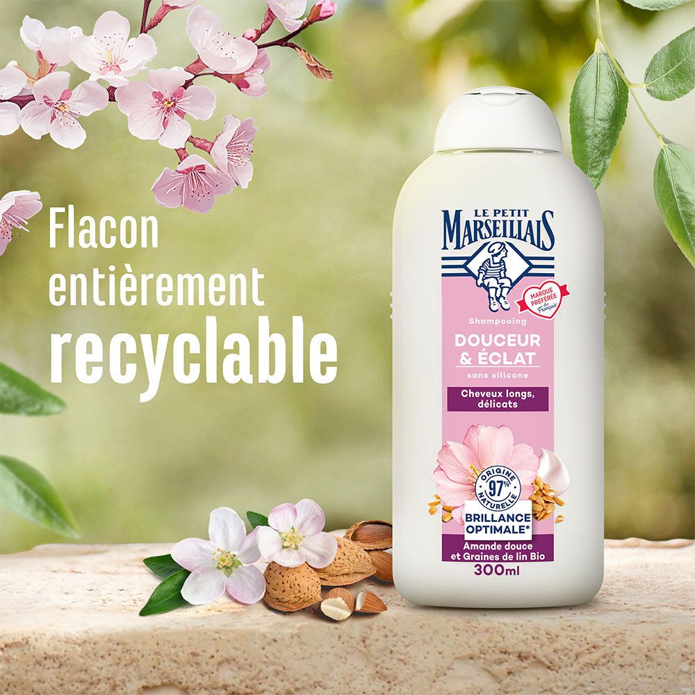 Shampoo fles met tekst. Achtergrond: bladeren, bloemen, zaden. Tekst: Flacon entièrement recyclable. Merk: Le Petit Marseillais.
