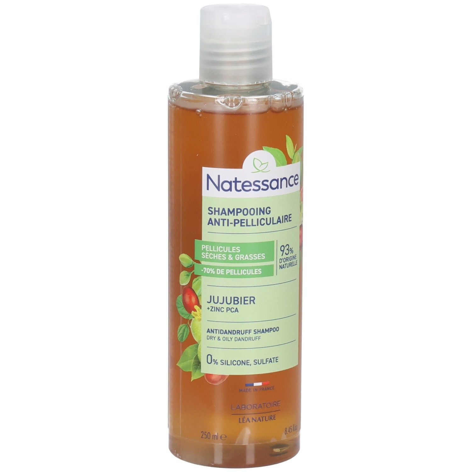 Flacon de shampooing avec bouchon blanc. Étiquette avec nom du produit, ingrédients et logo. Liquide ambré.