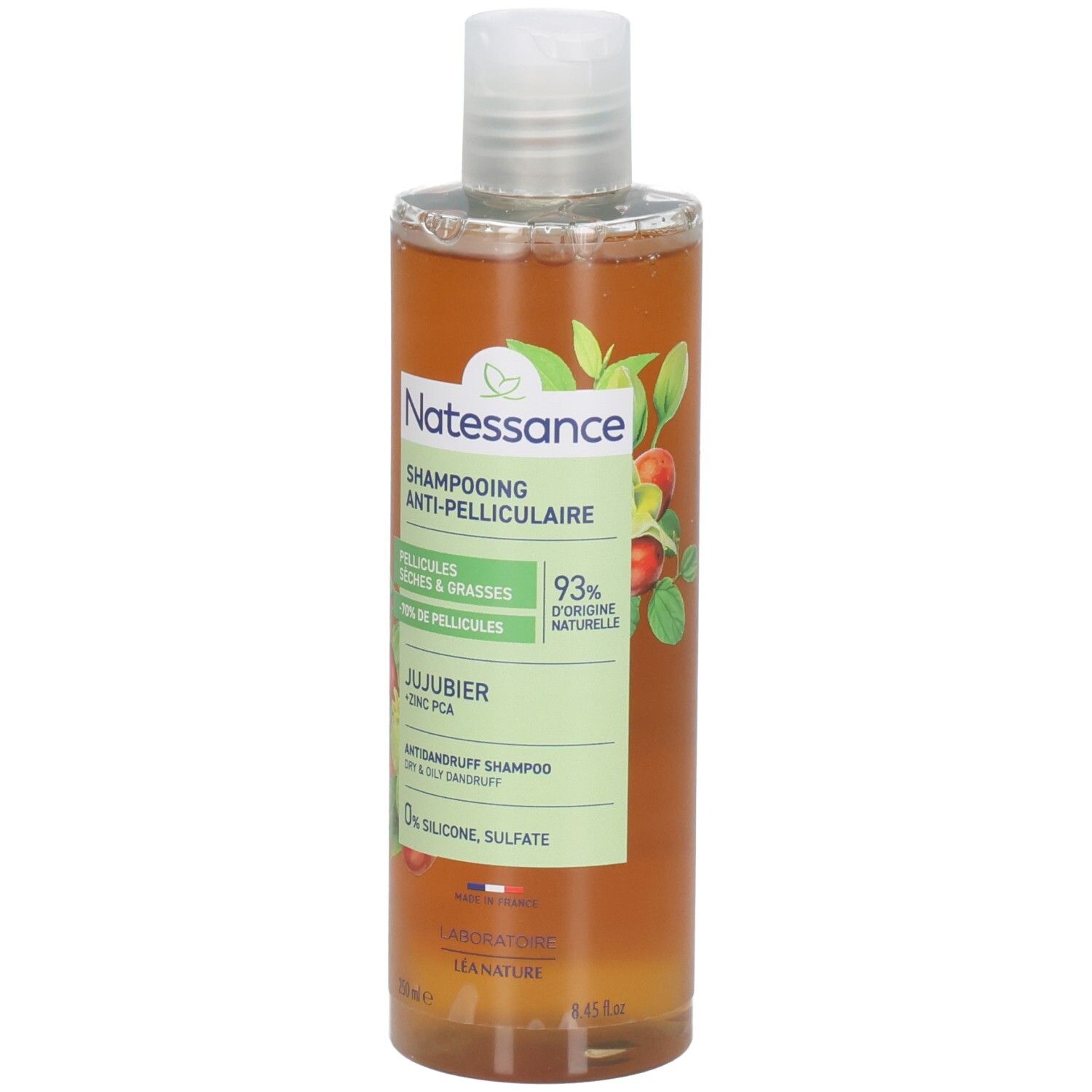 Flacon de shampooing avec bouchon blanc. Étiquette avec nom du produit, ingrédients et logo. Liquide ambré.