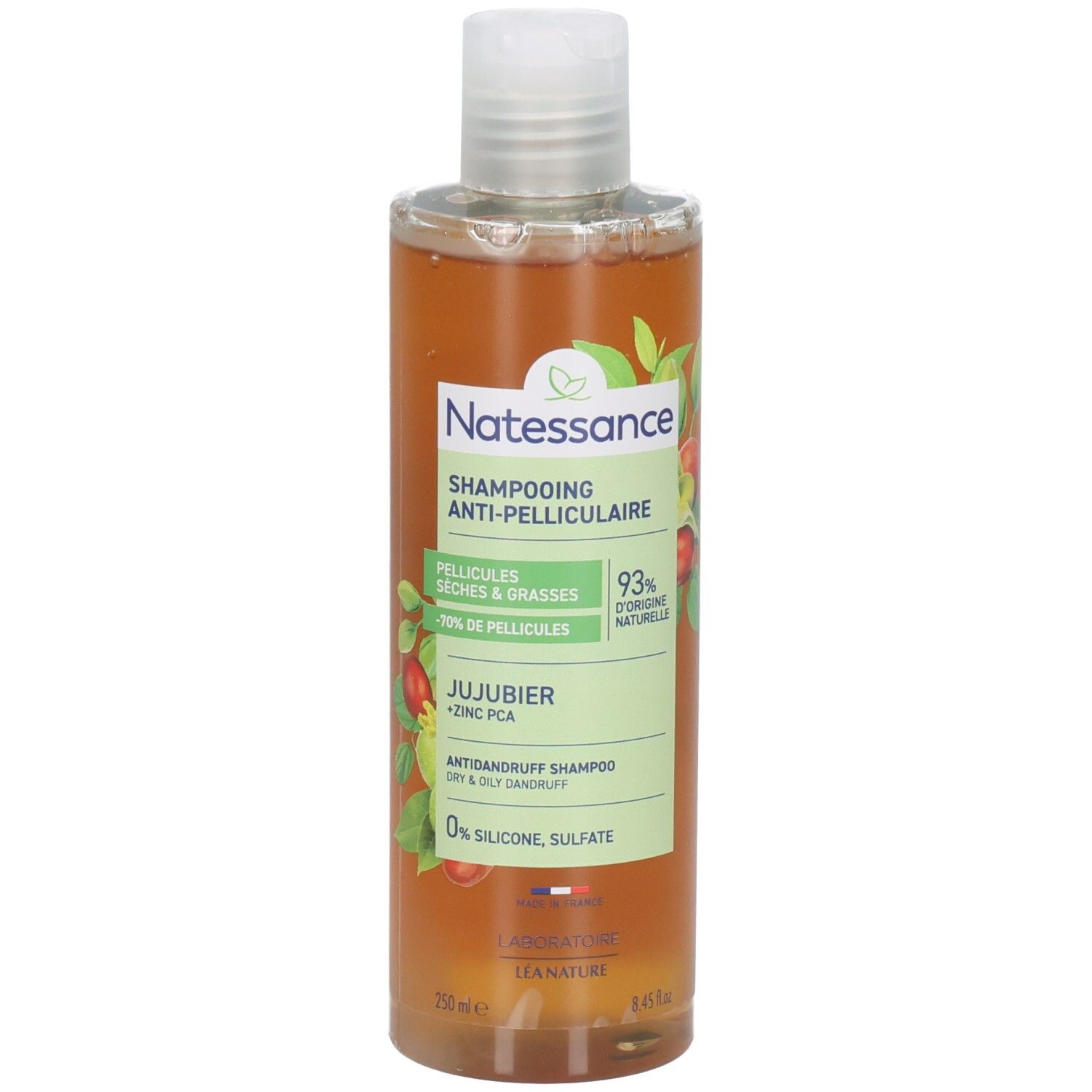 Flacon de shampooing avec bouchon blanc. Étiquette avec nom du produit, ingrédients et logo. Liquide ambré.