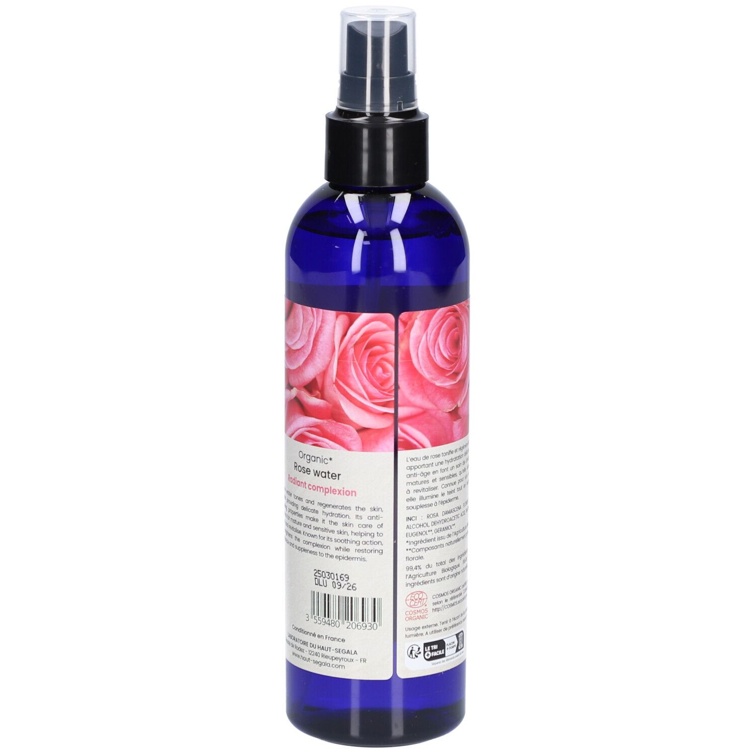 Blauwe fles met verstuiver. Achterkant met tekst en rozenmotief. Tekst: Organic Rose water. Bio-certificering. Houdbaarheidsdatum.